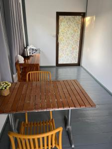 a wooden table and chairs in a room with a window at The Summer Guesthouse in Ban Khlong Son