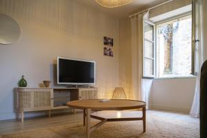 ドンムにあるGîte de la porte des toursのテレビとコーヒーテーブルのあるリビングルーム