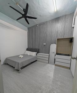a bedroom with a bed and a ceiling fan at Singgoh Tido Homestay in Bukit Payong