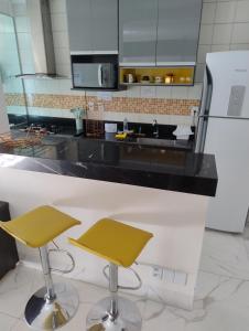 a kitchen with two bar stools and a sink at Spectacular apartment 202C - 7 thermal pools in Caldas Novas