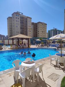 a pool with tables and chairs and people in the water at Spectacular apartment 202C - 7 thermal pools in Caldas Novas