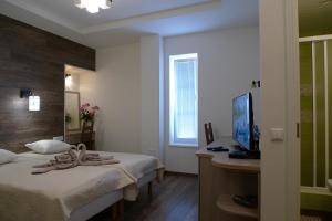 um quarto com 2 camas e uma secretária com uma televisão em Feyena Guesthouse em Vääna