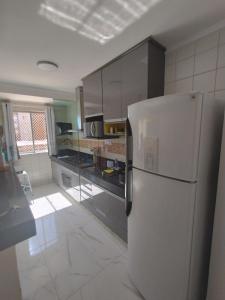 a kitchen with a white refrigerator in a room at Spectacular apartment 202C - 7 thermal pools in Caldas Novas +52 photos