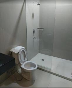 a white bathroom with a toilet and a shower at Harmadha Suite in Magetan