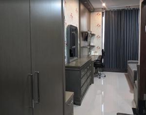 a room with a dresser with a mirror and a desk at Harmadha Suite in Magetan