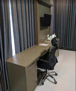an office with a desk and a black chair at Harmadha Suite in Magetan