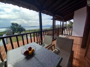 a table with a bowl of fruit on a balcony at Seaside Athos I in Ouranoupoli