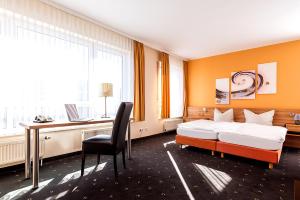 a bedroom with a bed and a desk with a computer at Hotel Casa Nostra in Schloß Holte-Stukenbrock