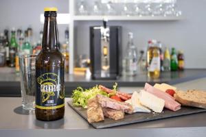 a bottle of beer next to a plate of food at Brit Hotel Mâcon Centre Gare in Mâcon +98 photos