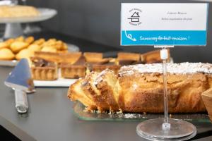 a bakery display with a loaf of cake and other pastries at Brit Hotel Mâcon Centre Gare in Mâcon