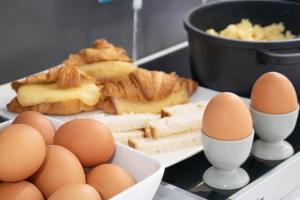 a plate of eggs and bread and a bowl of cheese at Brit Hotel Mâcon Centre Gare in Mâcon