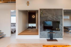 a living room with a flat screen tv on a wall at comma, shunko in Asahikawa