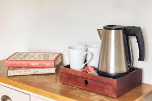 Una tetera y dos libros sobre un mostrador de madera. en Finest Retreats - Kelsick Villa Guest House - Gummers How, en Ambleside