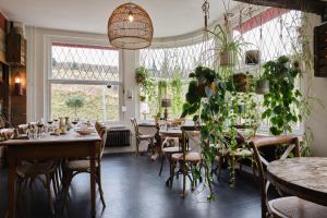 a restaurant with tables and chairs and a large window at Geulzicht Hotel in Schin op Geul
