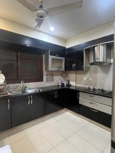 Η κουζίνα ή μικρή κουζίνα στο Zen Luxury Stay - 3BR Family Apartment DHA Phase 6 Nishat Commercial +25 φωτογραφίες