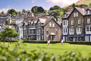 Dos personas jugando al golf en un campo frente a un castillo. en Finest Retreats - Kelsick Villa Guest House - Great Gable, en Ambleside