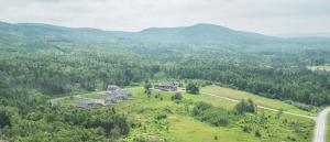 an aerial view of a house in the middle of a field at Cape Breton Flats in Inverness