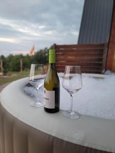 a bottle of wine and two glasses on a table at Krushevski Konaci 1 in Kruševo