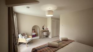 a bedroom with a bed and a chair at Easter Kincaple Garden Cottage in Guard Bridge