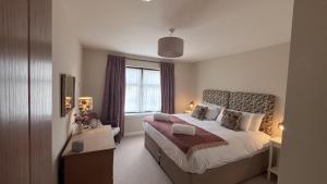 a hotel room with a bed and a window at Easter Kincaple Garden Cottage in St. Andrews