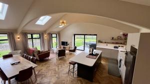 a living room with a kitchen and a dining room at Easter Kincaple Garden Cottage in Guard Bridge