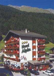a hotel alpha building with cars parked in a parking lot at Hotel Alpha in Saas-Grund