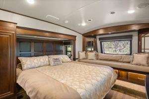 ein Hauptschlafzimmer mit einem Bett und einem Sofa in der Unterkunft Private Luxury RV Getaway Full Bath Kitchen Heating in Kendalia
