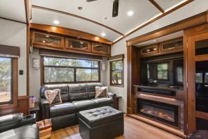 Una sala de estar con un sofá y una chimenea. en Twin Falls Luxury RV Glamping - Pinnacle, en Boerne