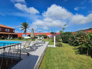 a group of chairs next to a swimming pool at A Casa do Comandante - Piscina e Jardim in Lagoa