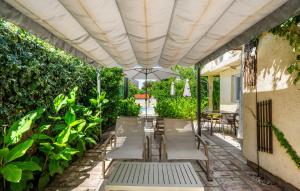 an outdoor patio with chairs and an umbrella at Regina Apartments in Brodarica