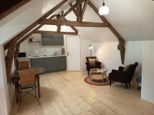 a kitchen and a living room with a table and chairs at Chez Alex, La Grange in Saint-Brieuc-des-Iffs
