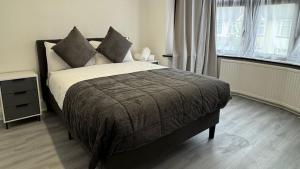 un dormitorio con una cama y una ventana en 4 Bedroom House - Romford, en Dagenham