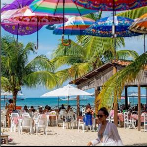 un grupo de personas sentadas en la playa bajo sombrillas en Escunha, en Salvador