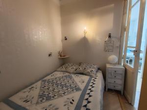 una piccola camera da letto con un letto e una finestra di appartement avec une superbe vue mer - 0014 a Soulac-sur-Mer