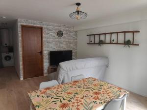 a living room with a couch and a table and a television at Le 15 du bessarel in Saint-Antonin
