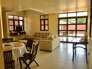 ein Wohnzimmer mit Tisch und Couch in der Unterkunft Casa-Z pertinho do mar in Barra de São Miguel