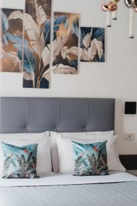 eine Gruppe von Gemälden an einer Wand über einem Bett in der Unterkunft La Residenza del Barone in Camerota