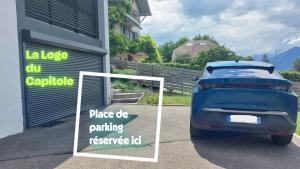 a car parked outside of a garage with a sign at La Loge du Capitole in Veyrier-du-Lac +3 photos