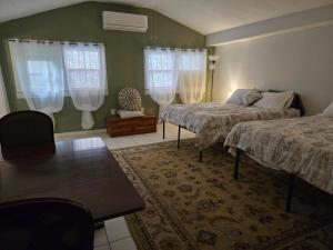 a bedroom with two beds and a table at Midtown Guest House in Mobile