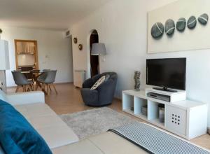 a living room with a flat screen tv and a couch at Heart Stone by the Sea in Lourinhã