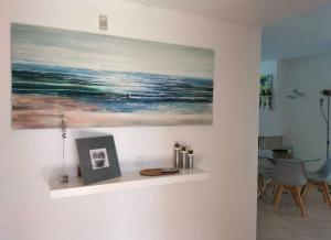 a painting on a wall above a shelf in a room at Heart Stone by the Sea in Lourinhã