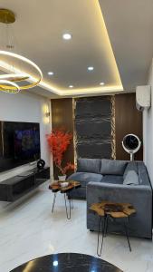 a living room with a blue couch and a tv at Luxury Private Top Floor Apartment in Heart of Bahria Town in Lahore
