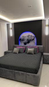 a bedroom with a large bed with a blue background at Luxury Private Top Floor Apartment in Heart of Bahria Town in Lahore
