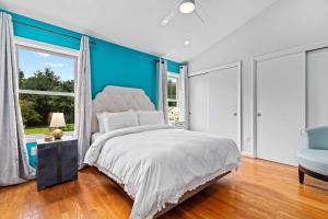 a bedroom with a large bed and a blue wall at The Pool Loft at Poplar Hill in Annapolis