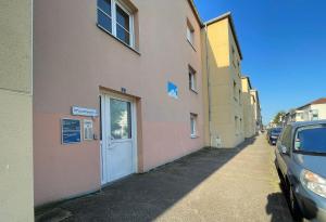 a building with a door and a car parked next to it at The 8 in Lunéville