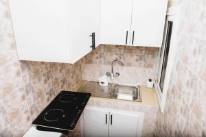 a small kitchen with a sink and a stove at Senlodge in Dakar