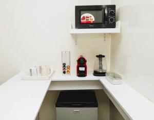 a kitchen with a counter with a microwave on a wall at Senlodge in Dakar