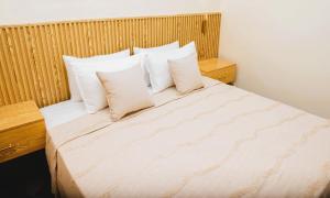 a bedroom with a bed with white sheets and pillows at Senlodge in Dakar