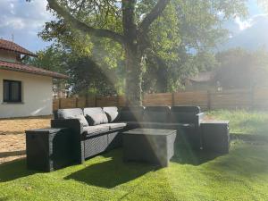 een bank en een tafel in een tuin met een boom bij Gîte Domaine d'Hybère in Lucbardez-et-Bargues