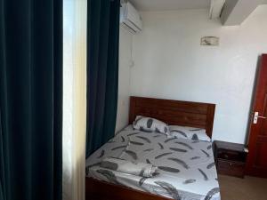 a bedroom with a bed with a blue curtain at HEILiG HOUSE in Dar es Salaam
